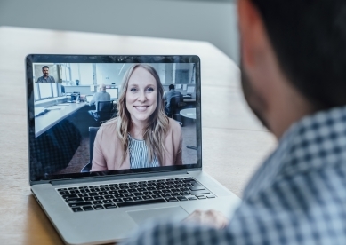 Man having phone conference with woman in office